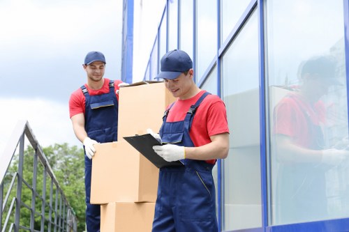Moving team handling boxes and furniture for a London apartment relocation
