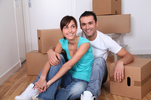 Professional movers carrying furniture through a London residential property