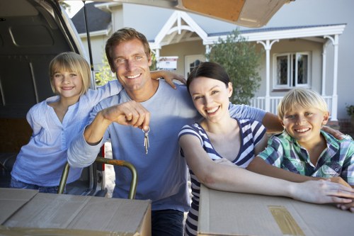 Professional movers preparing wrapped household items for transport in London